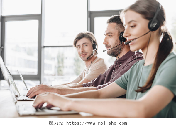 三个年轻人在室内工作年轻的呼叫中心经理团队在现代办公室工作